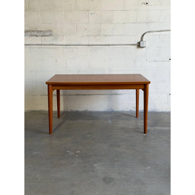 This dining table features a clean rectangular silhouette with integrated draw leaves for seamless expansion. Tapered legs...