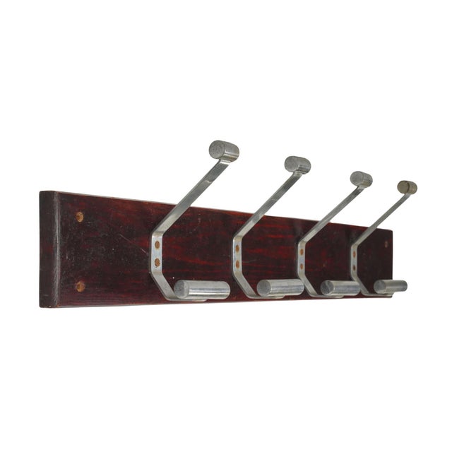 Vintage wall mount rack with four aluminum two arm hooks mounted on a dark stained wood plank. The original mounting...