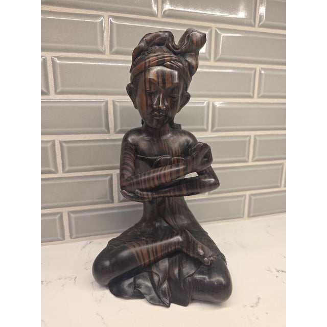 An exceptional mid-century Balinese modernist figure depicting a stylized seated young boy in a contemplative, cross-...