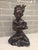 An exceptional mid-century Balinese modernist figure depicting a stylized seated young boy in a contemplative, cross-...