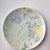 This vintage-inspired ceramic plate features hand-painted watercolor floral motifs in soft pastels—including pale blue...