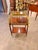 A striking French Louis XVI-style two-tier serving table featuring rich mahogany tones and beautifully detailed gilt...