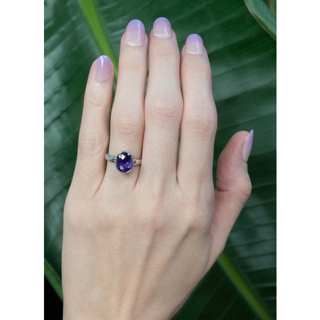 A rich 2.6Ct oval amethyst (11×8mm) glows beautifully in a sleek bezel setting, offering both elegance and everyday...