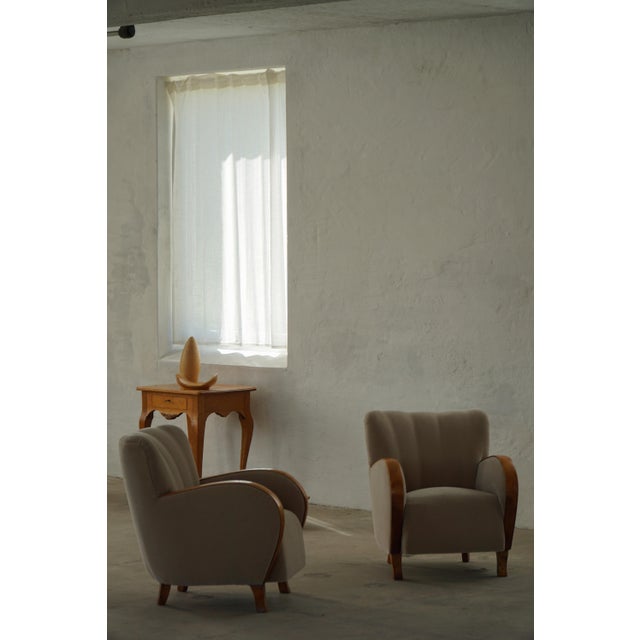 Elegant pair of Danish Art Deco lounge chairs from the 1940s, featuring softly rounded forms and a sculptural silhouette...