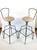 A modernist pair of Mid-Century wrought iron bar stools with a sculptural body, simple open frame backs, raised square...