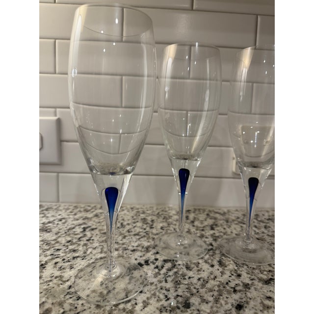 Set of 4 Orrefors Intermezzo champagne flutes with the signature cobalt blue drop in the stem. All glasses are in...