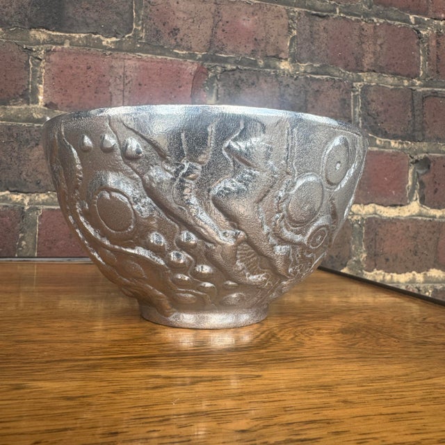 The Don Drumm BL64 is a collectible, heavy cast aluminum bowl featuring a silver textured abstract design.