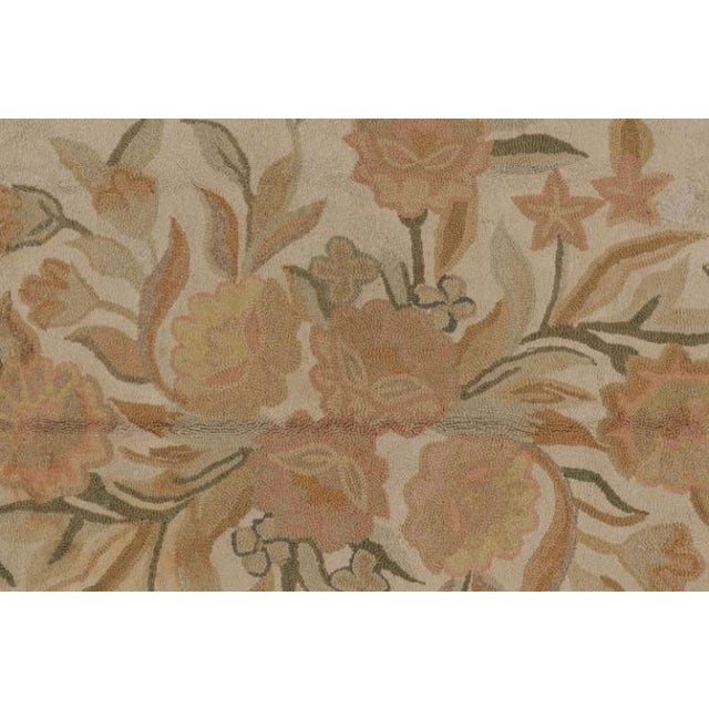 Handmade in wool, this antique hooked rug measures 8x11, circa 1920-1930. The design features a central floral bouquet...
