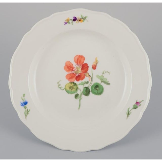 Meissen, Germany A set of four porcelain dinner plates. Hand-painted with different floral motifs. Approximately from...
