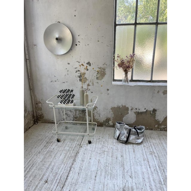 Cart or service trolley on the 80s composed of a broken white lacquered metal structure and two glass levels with white...