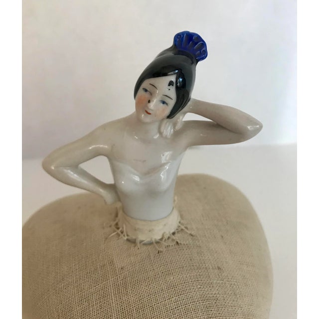 This is a fantastic piece from the early 1900's of a porcelain woman with a pin cushion dress made of linen/burlap in the...