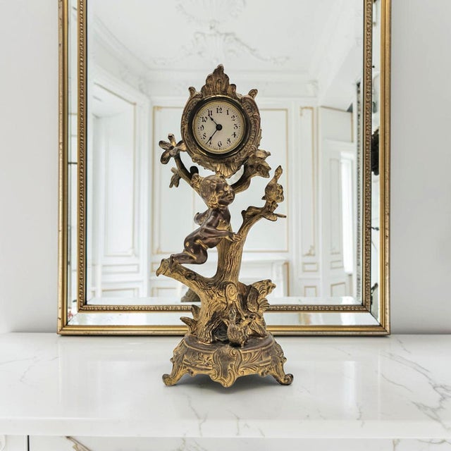 Figural mantel or desk clock depicting a young girl accompanied by ducks beneath a tree shaped clock support. Produced...
