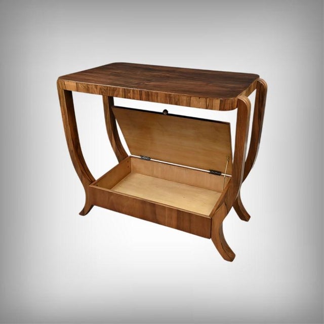 This Art Deco console table captivates with its sculptural elegance and functional ingenuity. Crafted from walnut veneer,...