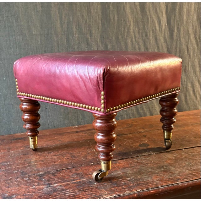 Charming little ottoman with turned legs and brass casters.