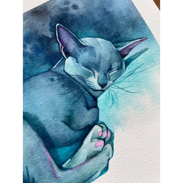 Nestled in Blue by Chris Hong | Watercolour on paper of a sleeping blue cat For Sale
