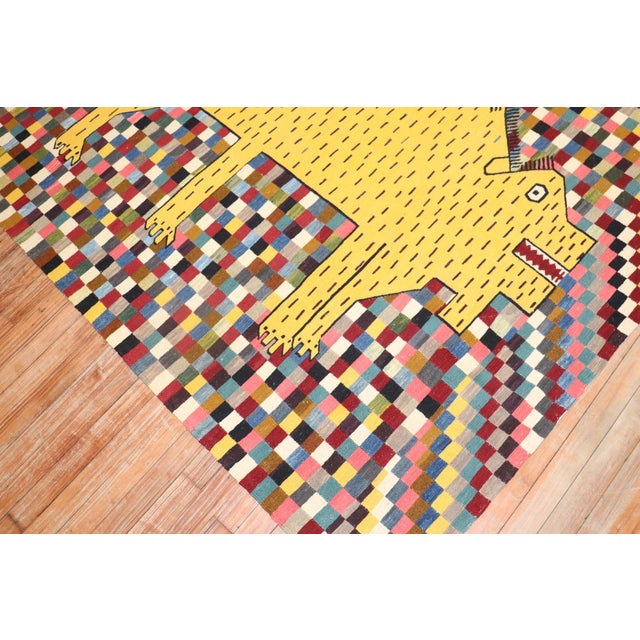 Late 20th Century Persian Kilim with a yellow rhinoceros on a colorful checkered field. Measures: 4'11'' x 6'11''.