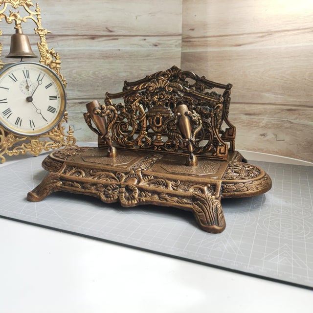 This heavy antique desktop stationery organizer and pen rest, dating from the first half of the 20th century, is an...