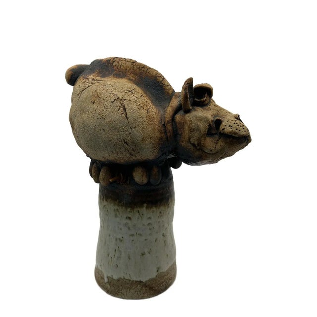 This whimsical cow with the exaggerated large head is attached to a bell shaped base. It is a stoneware sculpture as well...