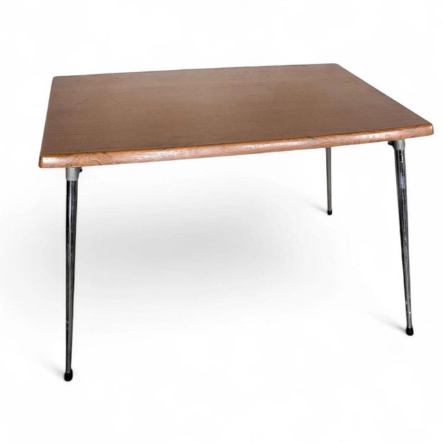 This mid century dining table combines vintage charm with modern durability, featuring a teak veneer top and sleek chrome...