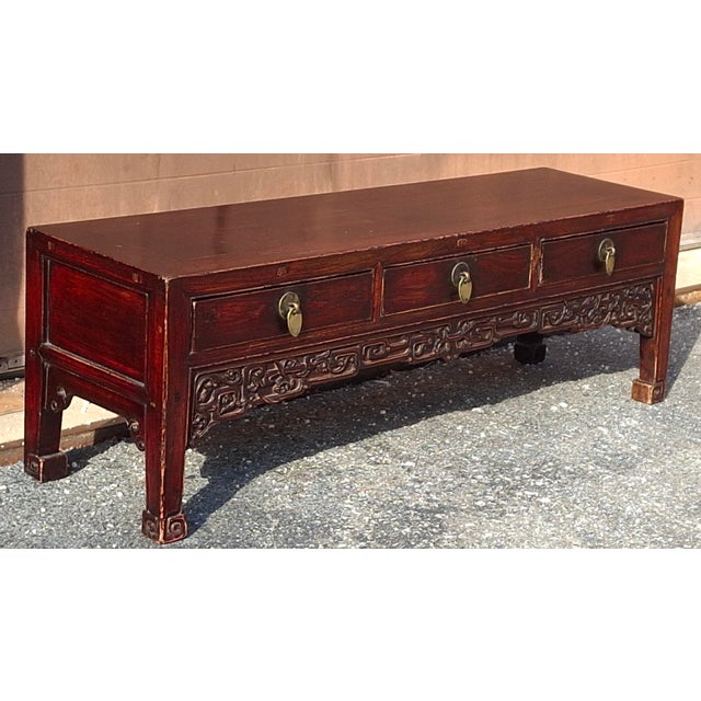 A l19th Century Chinese Rouge Lacquered and carved Elmwood three drawer Kang Table. Measures 48" in width, 14" in depth,...