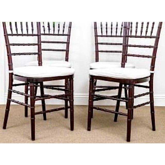 Chic Set Of Four Faux Bamboo Wooden Chiavari style Chairs. Bamboo spindle style back, solid wood seat. Legs are joined...