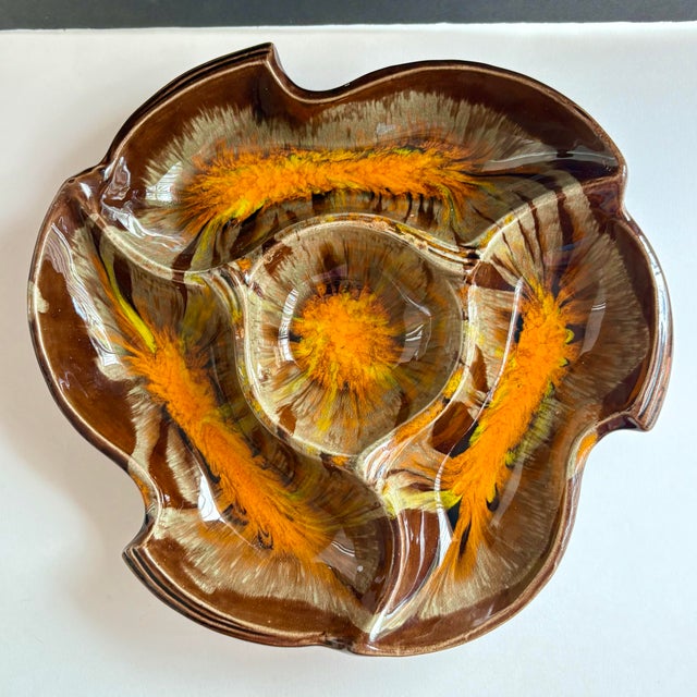 A wonderfully sculptural vintage California pottery serving dish featuring an expressive orange, brown, yellow and earth-...