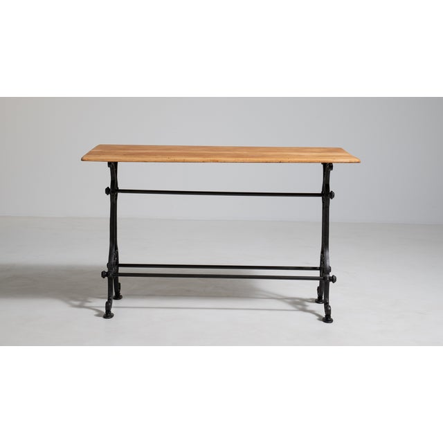 A traditional French early 20th century cast iron bistro table with clean proportions and a solid iron base, representing...