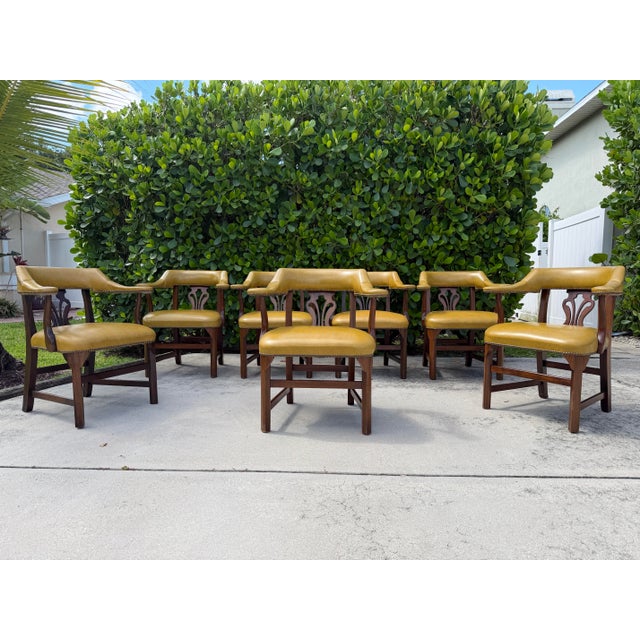 Distinctive set of seven Williamsburg-style smoking armchairs by RWAY, featuring rich mustard upholstery, sculptural...