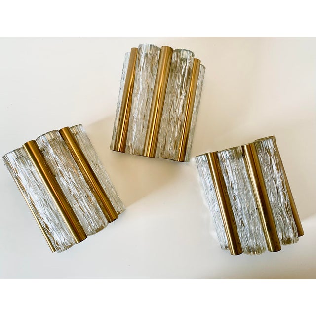 Ice glass wall lamp from the 1960s by Kaiser Leuchten/Kaiser Idell. The lamp features an ice glass shade and brass...