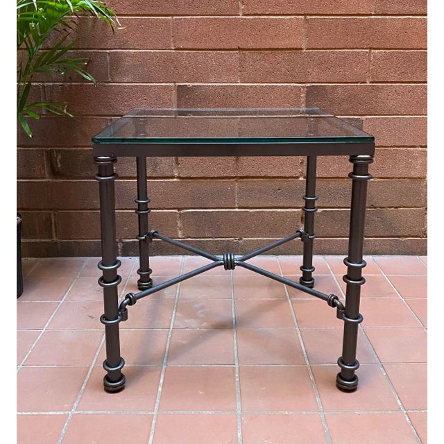 Mid Century slate black iron side table table in the style of Diego Giacometti with a thick glass top.