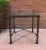 Mid Century slate black iron side table table in the style of Diego Giacometti with a thick glass top.