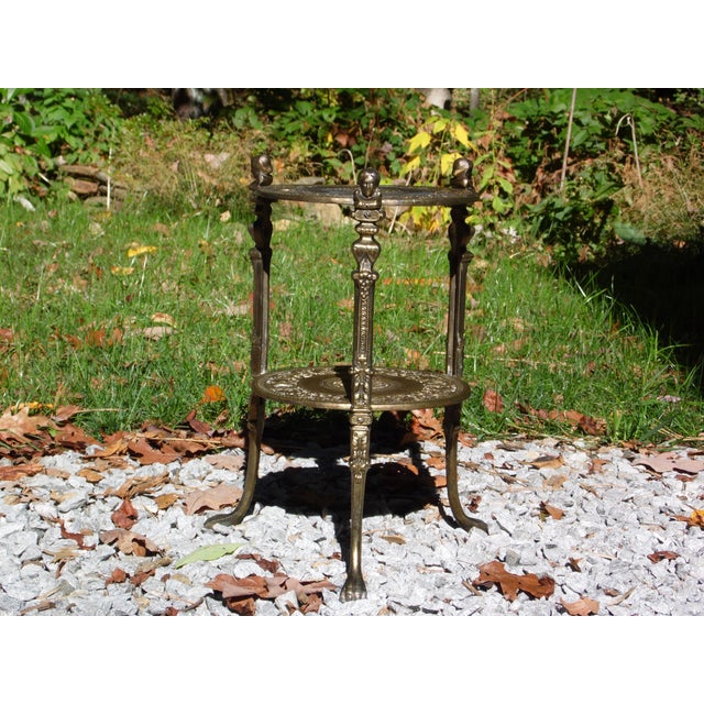Vintage Gold Gilt Metal Stand Tiered Tripod Gueridon Table features ornate details with an antique distressed gold color....