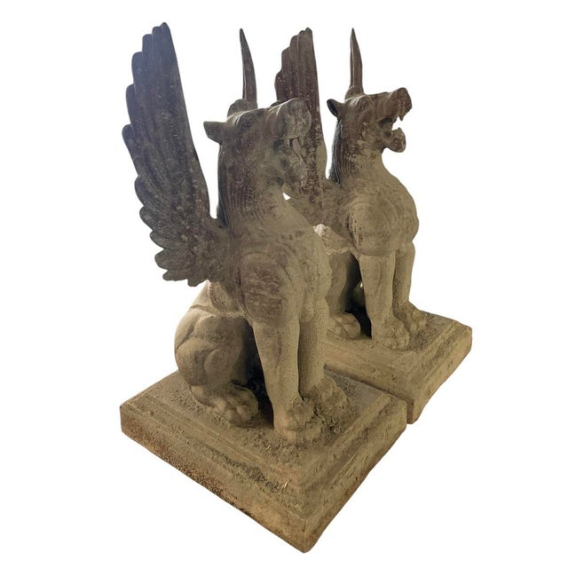 This striking pair of monumental cast iron statues features a commanding neoclassical presentation of winged griffins,...