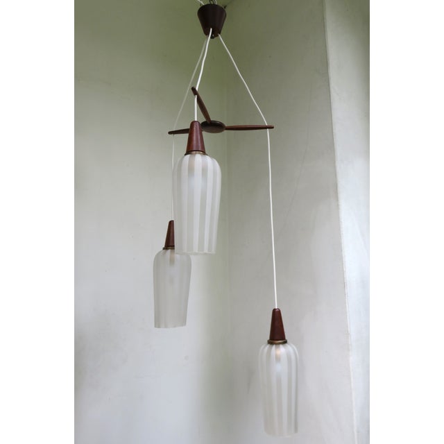 A ceiling light in Scandinavian design, made in the 60s. The combination of teak wood with patinated brass and large...