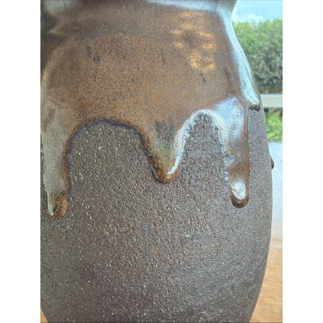 Offered is a substantial hand-thrown studio pottery vase featuring a richly textured dark stoneware body with a glossy...