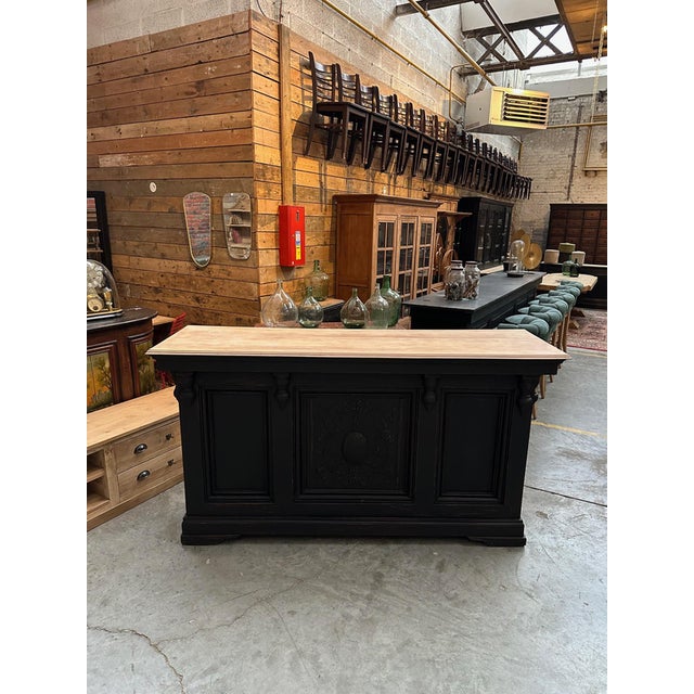 Cet ancien comptoir de bar a été entièrement restauré Son corps patiné noir est en sapin et son plateau est en hêtre...