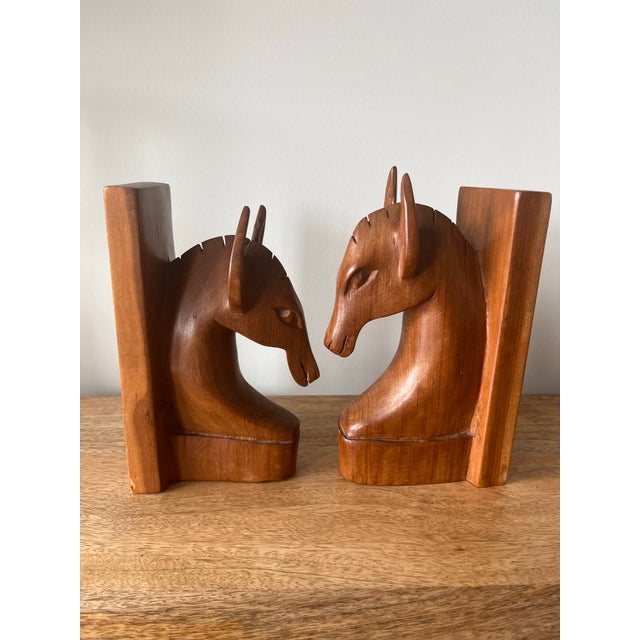 A gorgeous handcarved team of horses. One male and one female each carved out of a rich caramel colored wood.