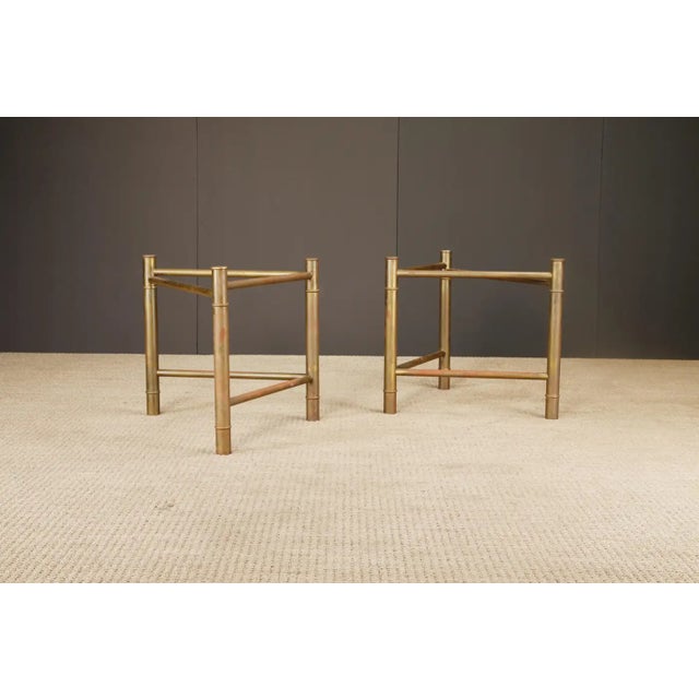 A sculptural pair of Mid-Century Modern table bases by Mastercraft, crafted in brass with a richly aged patina and...