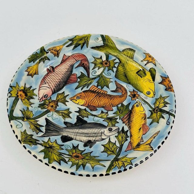 Five individually detailed fish swim through a dense tangle of spiky serrated foliage and yellow blossoms across the...