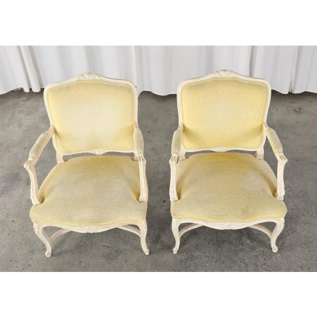 Country French provincial or Louis XV style pair of painted fauteuil armchairs. The set features a generous seating area...