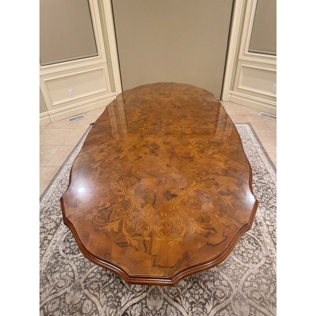 This is a beautiful vintage/antique-style carved wood dining table with an exceptional burl wood and marquetry-style top....