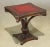 A pair of fancy carved mahogany leather top lamp tables. Inset red burgundy leather tops with gold trim. Styled after the...