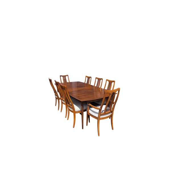 The Halle Bros Mid Century Modern Walnut Cane Back Dining Room Set includes 8 chairs and a matching rectangular dining...