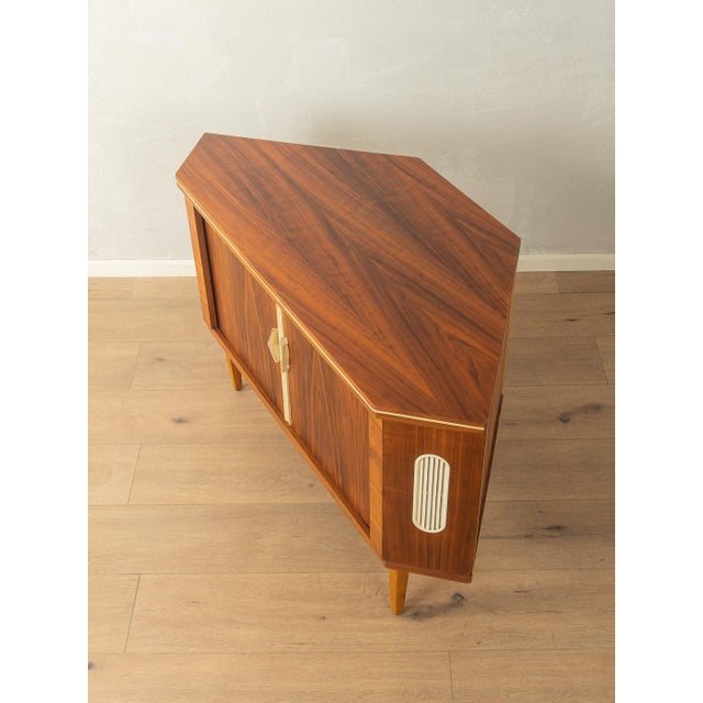 A wonderful corner cabinet from the 1950s with an integrated bar compartment. High-quality walnut veneer body with two...