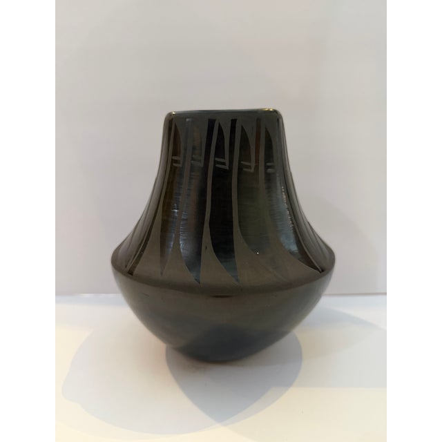 Signed Santa Clara Pueblo black pottery vase by acclaimed Native American potter Madeline Tafoya (1912–2002). This elegant...