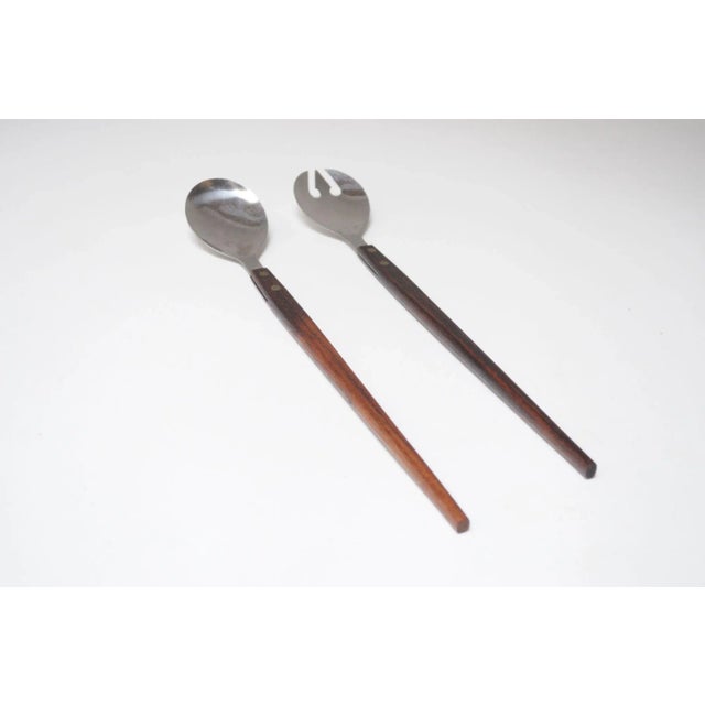 Vintage set of salad tongs in stainless steel and rosewood (ca. 1960s, Japan). Modernist design with pitchfork-form...