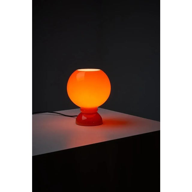 Very nice Space Age table lamp. Made completely from glass. The glass has an orange color and is white on the inside....