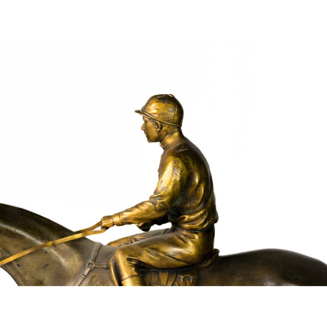 A French Jockey à Cheval tabletop sculpture from the Napoleon III period crafted in gilt and patinated bronze, depicting a...