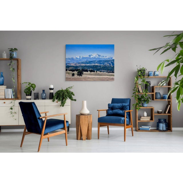 In "Colorado Plains," expansive mountains dominate the landscape, their snow-capped peaks contrasting sharply with the...