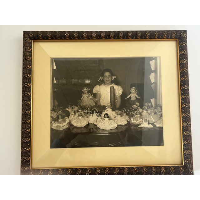 Beautifully framed image of young girl proudly displaying her Madame Alexander Doll Collection, circa 1950.